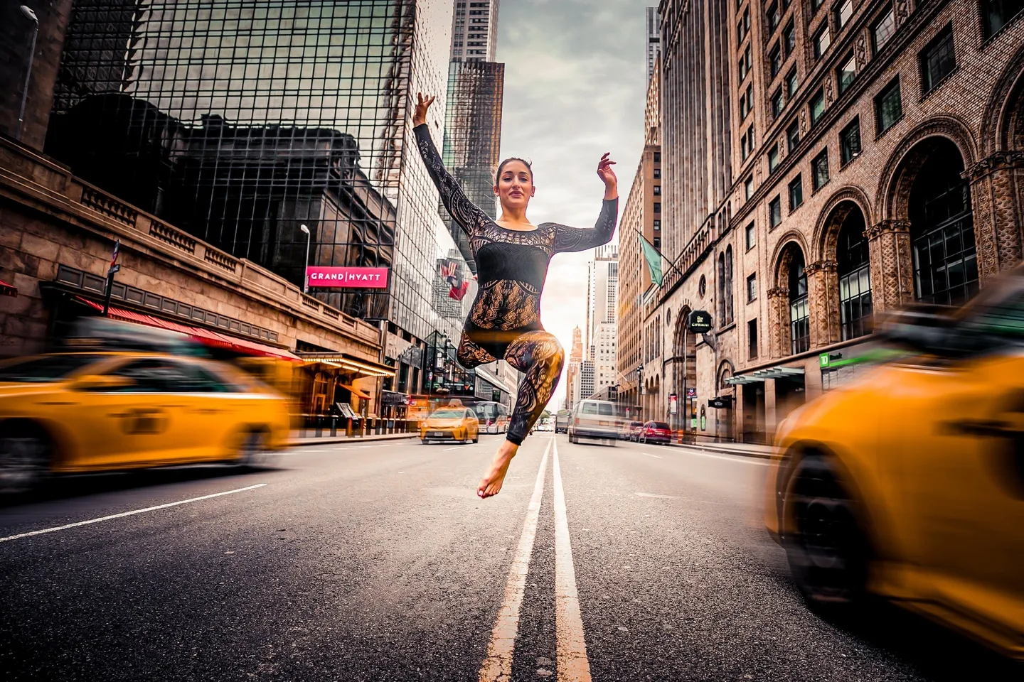 A woman jumping in the air on a street.
