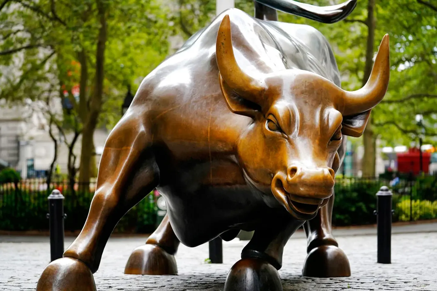 Bronze sculpture of a charging bull in a Manhattan city plaza.