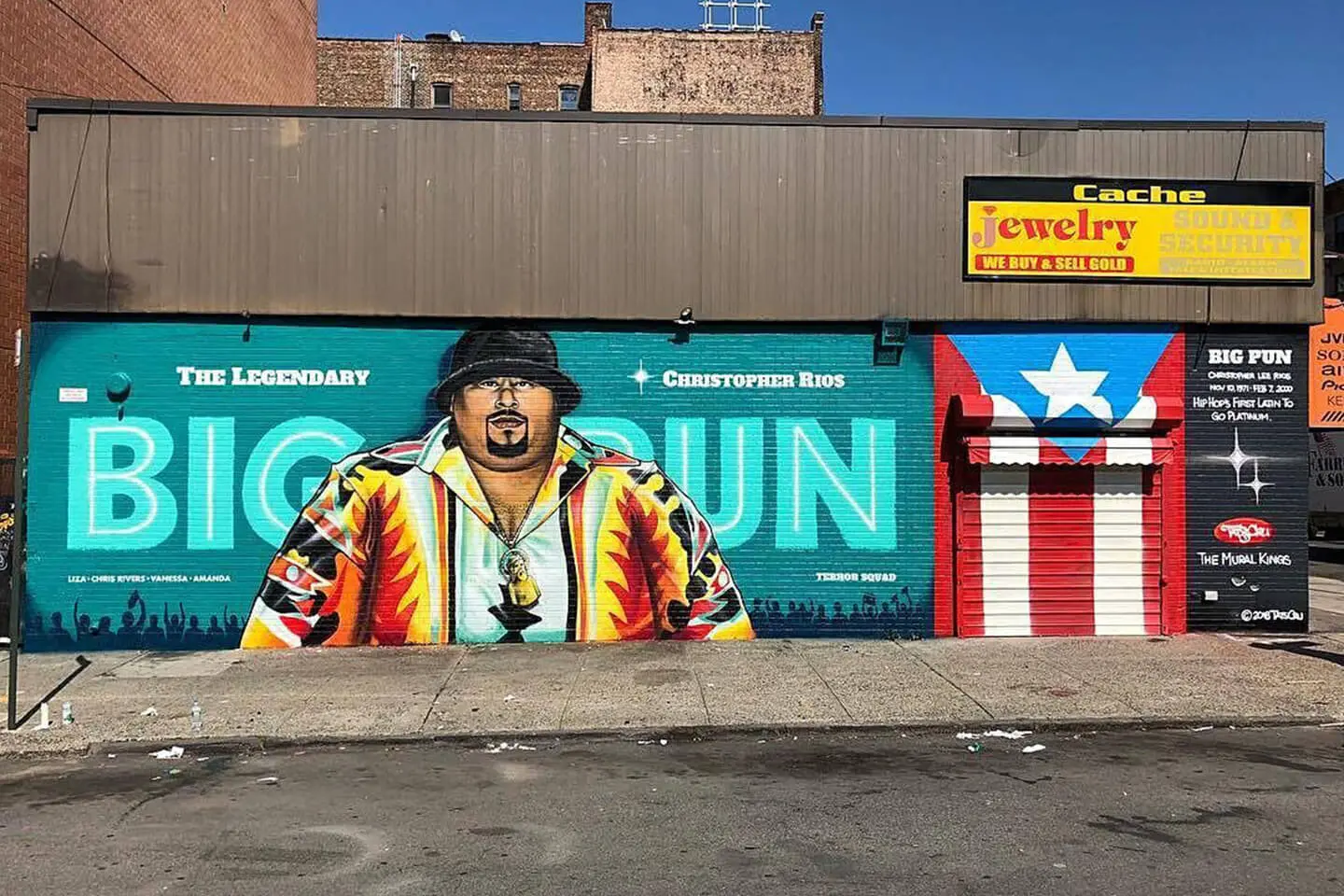 A vibrant street mural of notorious b.i.g., a legendary rapper, adorns a building's facade alongside urban storefronts in Manhattan.